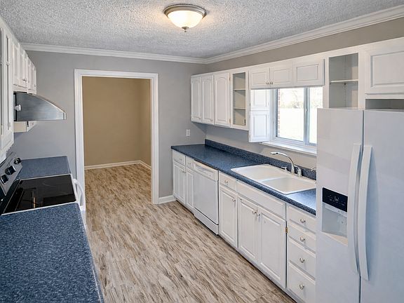 Bright, updated kitchen featuring crisp white cabinetry and generous counter space with natural light from the window over the sink_clean, functional, and move-in ready.