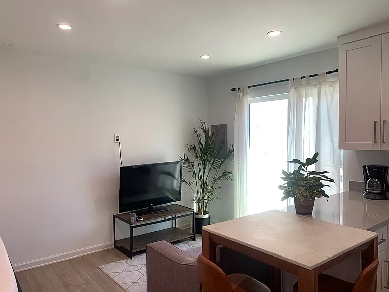 living room with couch, rug, table and chairs.