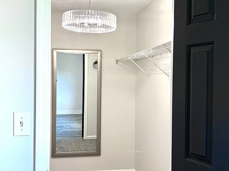Large walk-in primary closet / dressing area, with full length mirror and glamorous lighting!