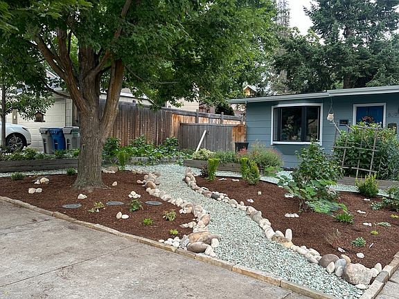 Front of the house with four raised beds.