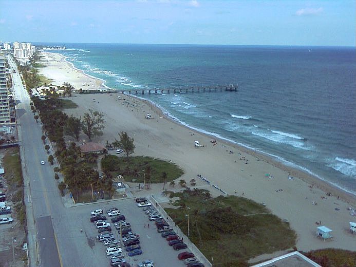The view of the lighthouse, the pier, and the beach from the balcony