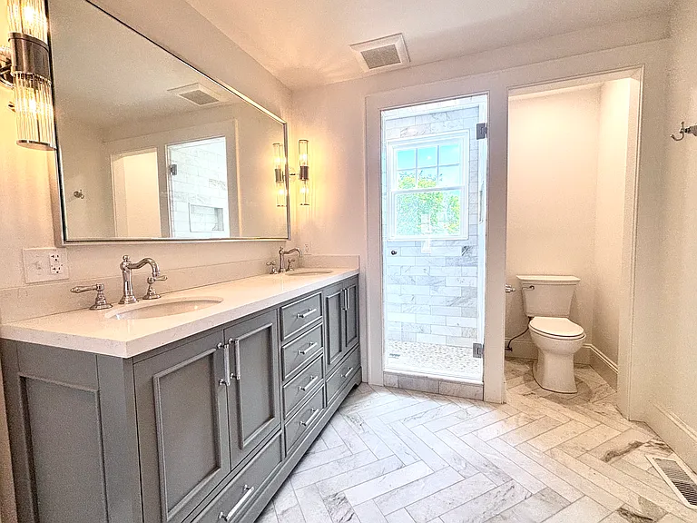 Primary Marble Bathroom with double sinks and linen closet.