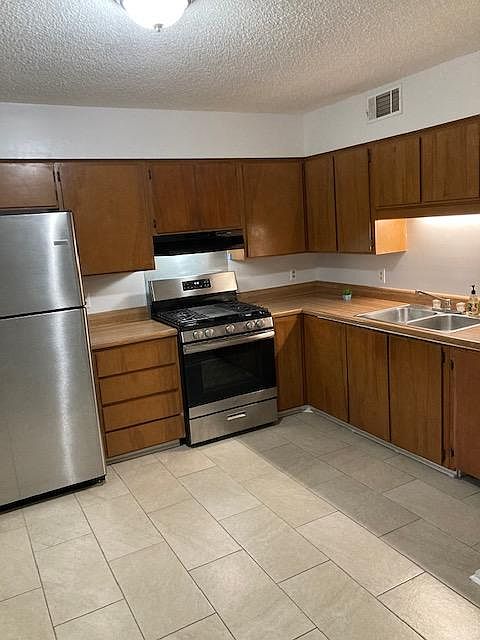 Kitchen, tile floor, ample storage. Model shown, 
This town house setup has white kitchen appliances.