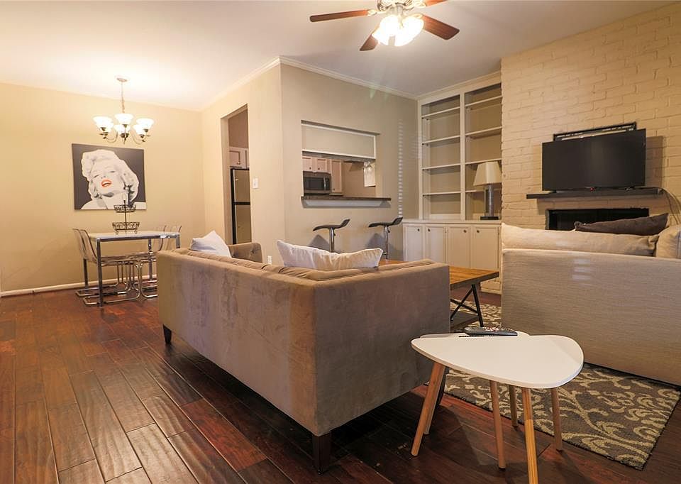 Living room with wood flooring, natural light, and open to the kitchen, office and dining area. (staged photo)