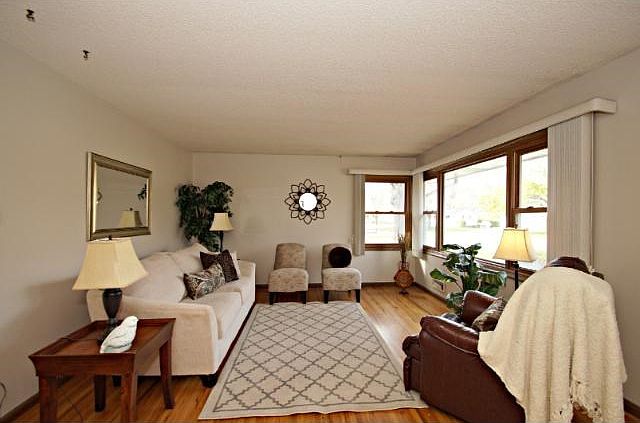 Large living room with huge {and new} picture window and gleaming hardwood floors.