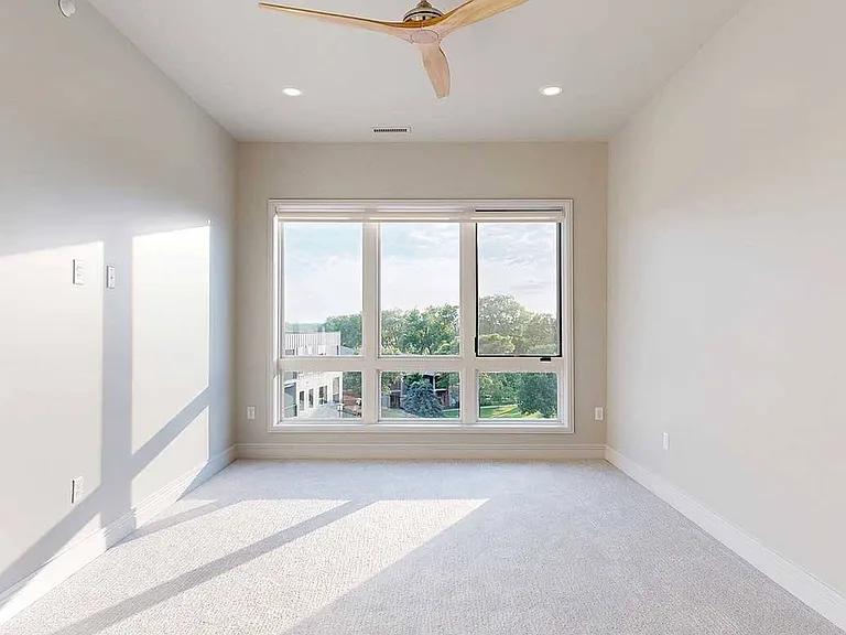 Rest and recharge in the spacious primary bedroom of the Wrangler Penthouse, where floor-to-ceiling windows frame scenic views and natural light fills the space.