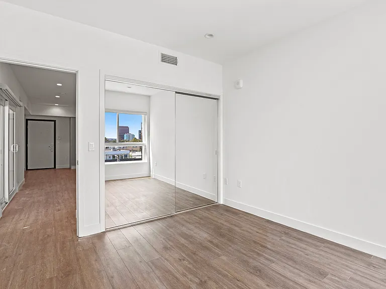 Bedroom with Mirrored Closet and Vinyl Flooring