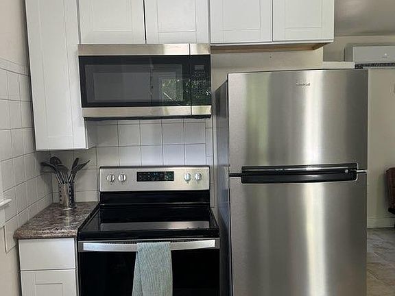 30" gas range, microwave hood, stainless steel appliances, kitchen cabinets.