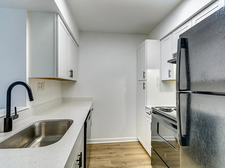 White cabinetry and black appliances accentuate this bright, newly renovated kitchen at ReNew on Cantrell.