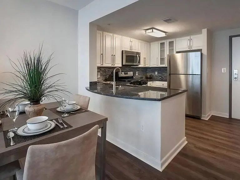 Dining Table and Kitchen With Granite Counters and Stainless Appliances