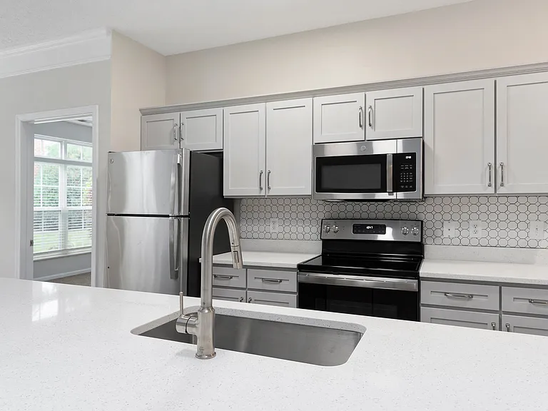 The Charleston Magnolia Premium Renovated Kitchen with Quartz Countertops, Brushed Nickel Fixtures, Gooseneck Kitchen Faucet, Modern Backsplash, Stainless Steel Appliances