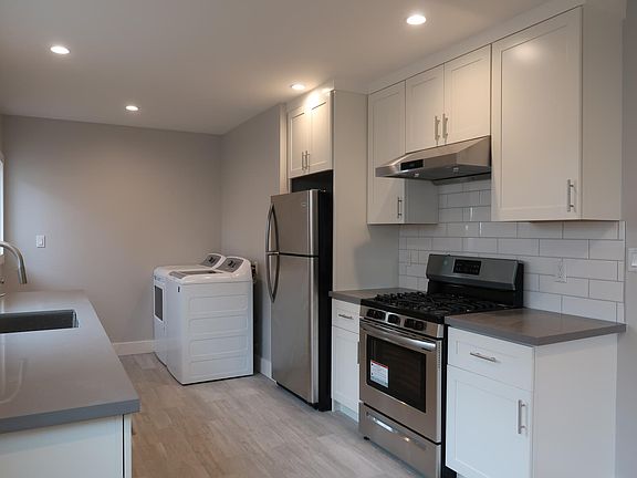 Kitchen to laundry area. Back exit toward left with access to yard.