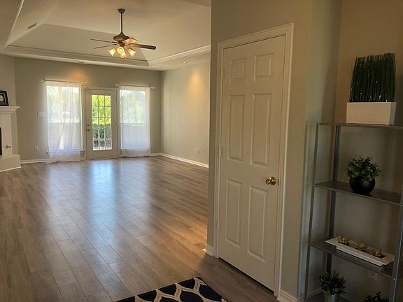 Large, light-filled living room with fireplace leads to covered back area, ample patio and huge backyard.