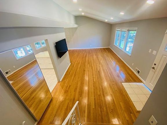 View of Living Room and its elevated/slanted ceiling with recessed lights, Wall mounted LG TV left for your use