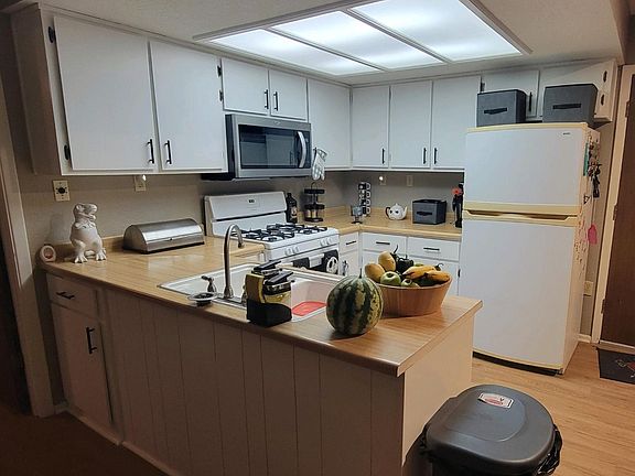 kitchen has gas range, microwave hood, plenty of cabinet space and refrigerator