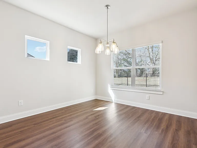 Bright room with wood floors and a large window, perfect for a kitchen table.