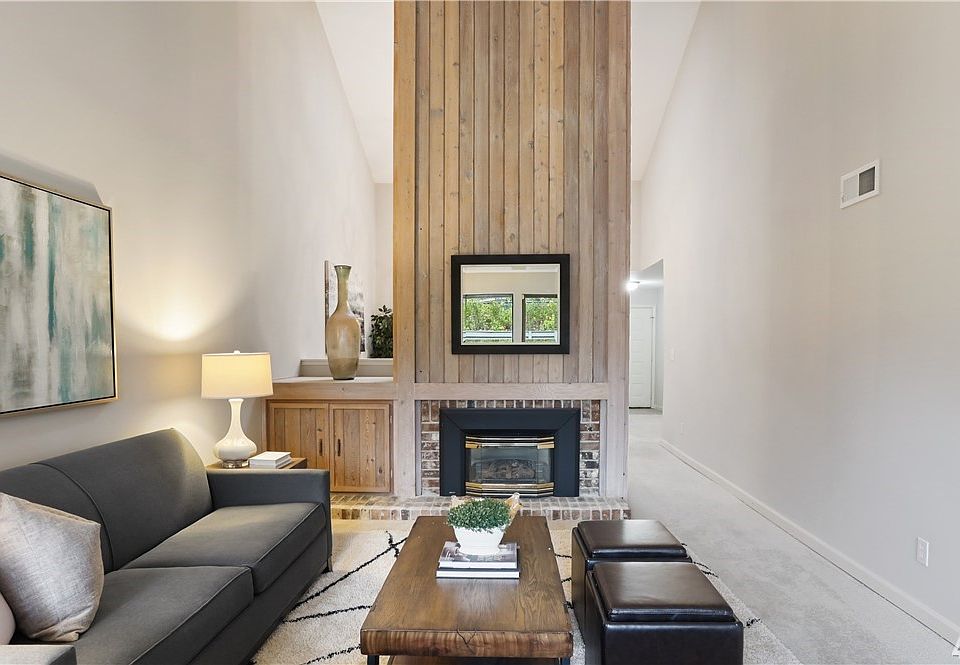 Vaulted ceilings with clerestory windows bring drama and light to both the living room and dining room spaces that you're sure to enjoy. Brand new carpet is perfect for cozy nights home in Bellevue while you relax inside, right next to the fireplace. 