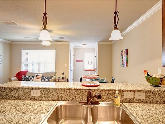 View of Kitchen looking in the living room with a double sink, granite counters, accent lighting and breakfast bar