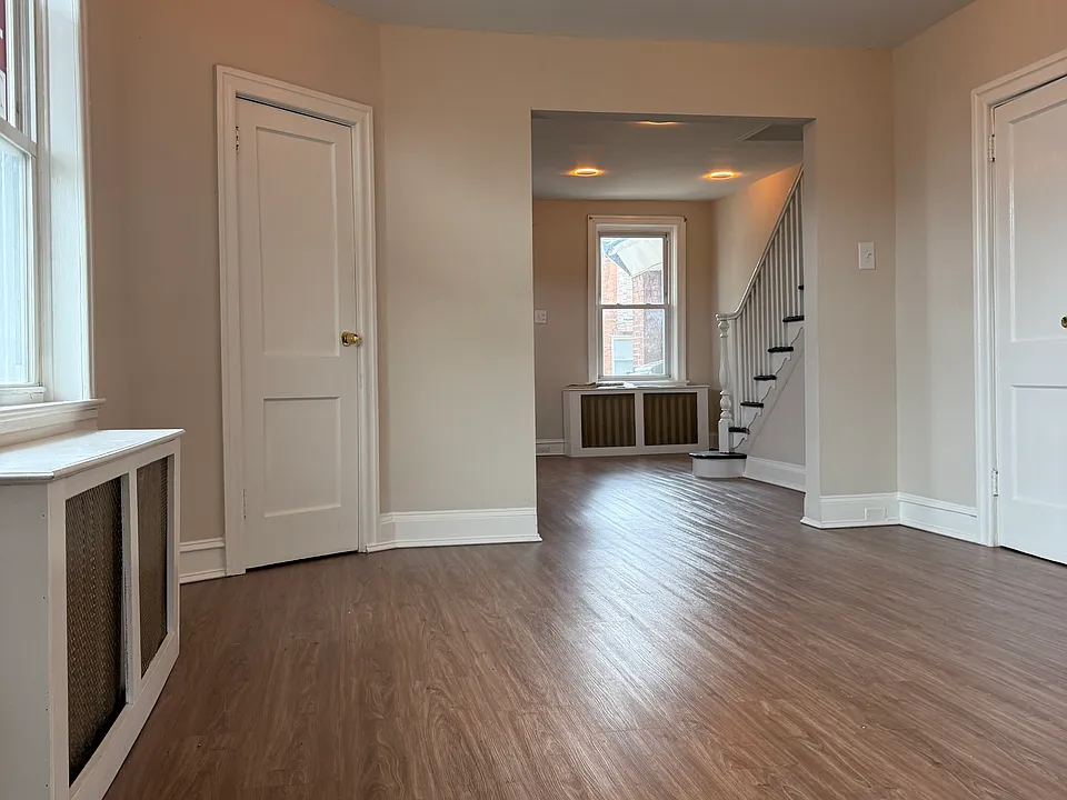 Open first-floor living space with updated flooring, recessed lighting, and room for both living and dining areas.
