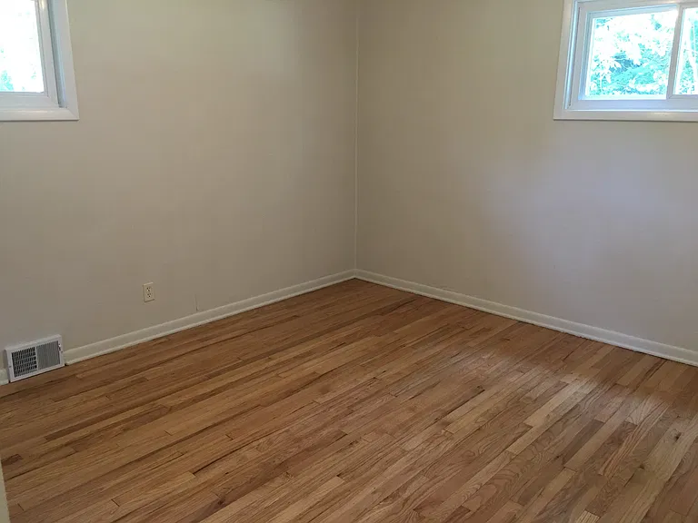 Primary bedroom with refinished oak hardwood floors.