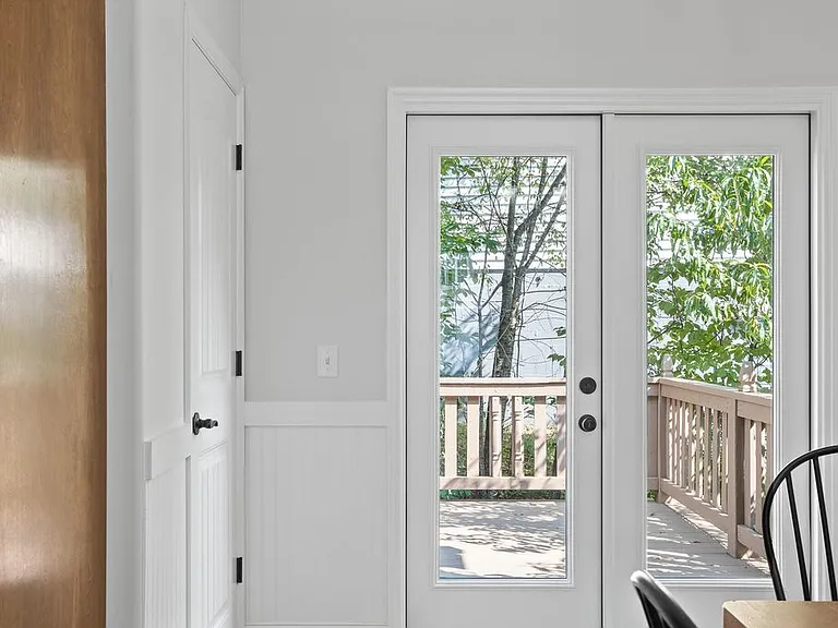 French doors leading out to backyard deck. Walk-in pantry door behind kitchen.