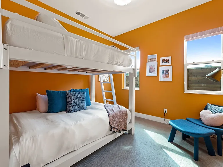 Room with orange walls, two windows, and a built-in bunk bed frame