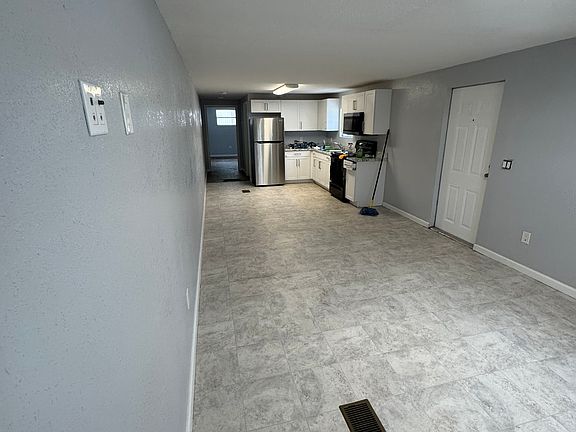 Living room looking at kitchen and bedroom hallway