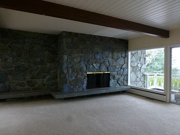 Stone wood burning fireplace in the living room with built in bench or shelf.