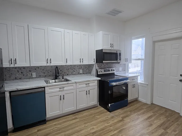 Renovated kitchen leading to balcony.