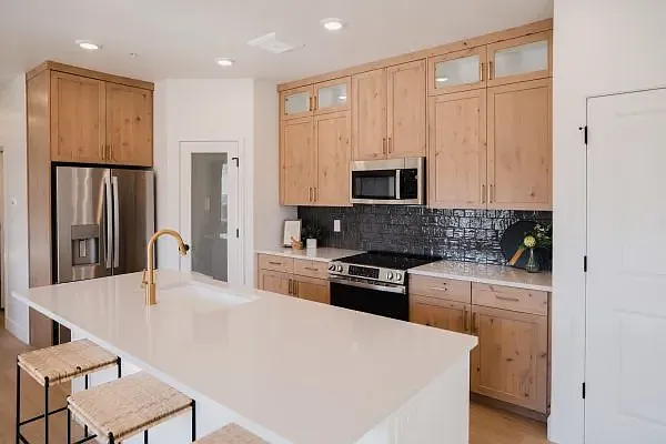 Staged photo. Condo has white cabinets with black hardware.