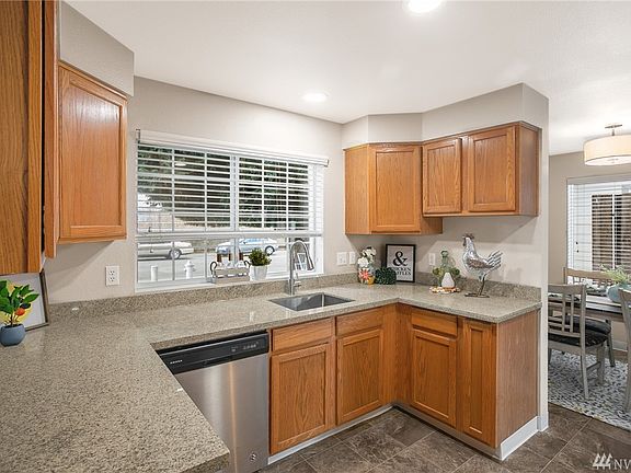 The cheerful kitchen boasts new granite counters and a stainless single bowl undermount sink. 