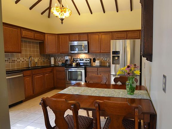 Eat-in kitchen with vaulted ceiling, cherry cabinets and gra