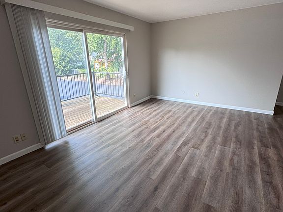 LIVING ROOM WITH SLIDING GLASS DOOR TO BALCONY - TAKEN FROM ENTRANCE DOOR