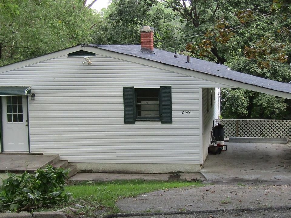 House front with carport, outside storage area under the car
