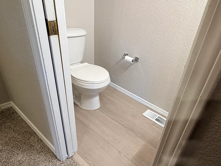 Convenient main-level half bath with new LVP flooring installed 6/5/2026, and pocket door for improved flow and privacy.