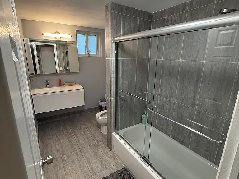 Second Bathroom
Updated second bathroom with full soaking tub, glass sliding doors, floor-to-ceiling tile, floating vanity, and large format tile floors _ stylish and functional
