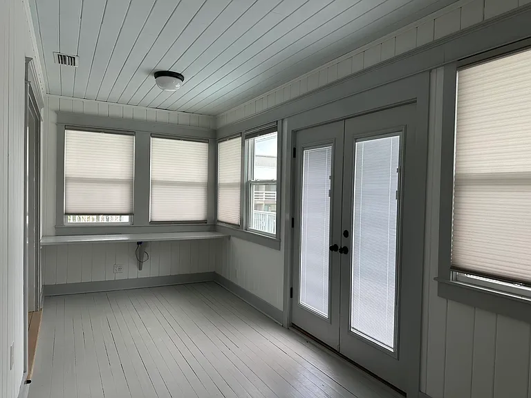 Enclosed sunporch off of kitchen with french doors to deck