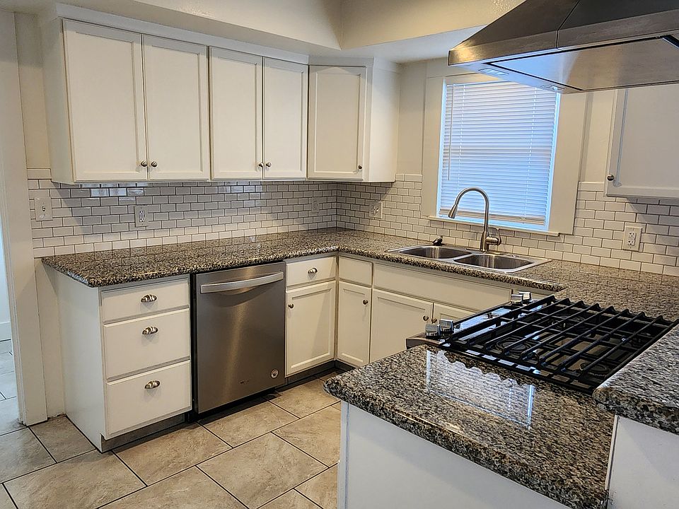 Beautiful modern kitchen with gas range, stainless steel range hood and dishwasher