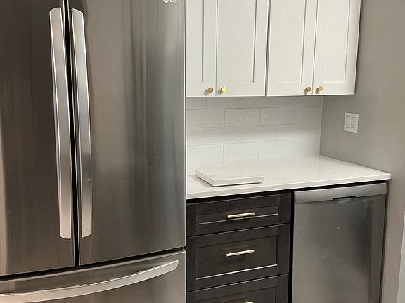 Large capacity refrigerator with French doors and two freezer drawers, also a stainless dishwasher.