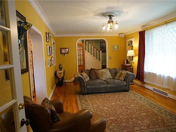Living room with view to entry hall. Hardwood floors throughout home.