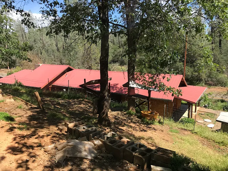 The 1.8 acre property rises behind the house to a small covered horse stall