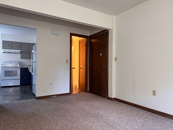Entryway into the living room. Open door is the bathroom. Pass-thru to kitchen and dining.