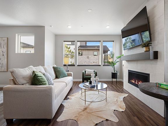 Spacious living room with fireplace and large picture windows with beautiful views of the open space and hillside where elk and deer are often seen grazing.