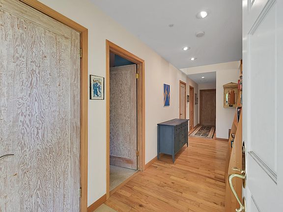 Hall seen from the entrance door with bedrooms on the left and living room and kitchen on the right