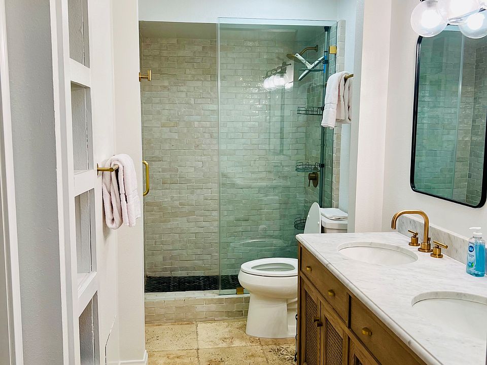 Primary bathroom with glass shower doors, new super-flusher commode and double sinks