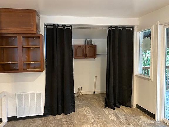 Washer Dryer hookups in Laundry Room off of kitchen with cabinet and shelf for storing supplies.