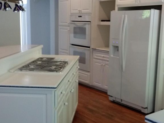kitchen, gas stove, double ovens, refrigerator, corian count
