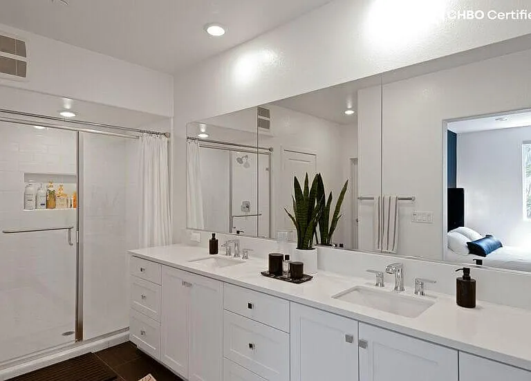 Spa-inspired bathroom with dual sinks, large walk-in closet