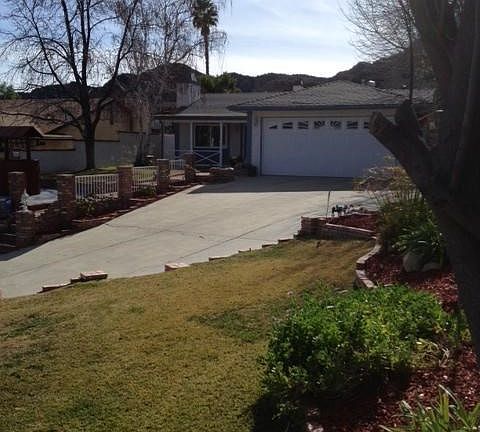 Home offers long driveway and landscaped area show