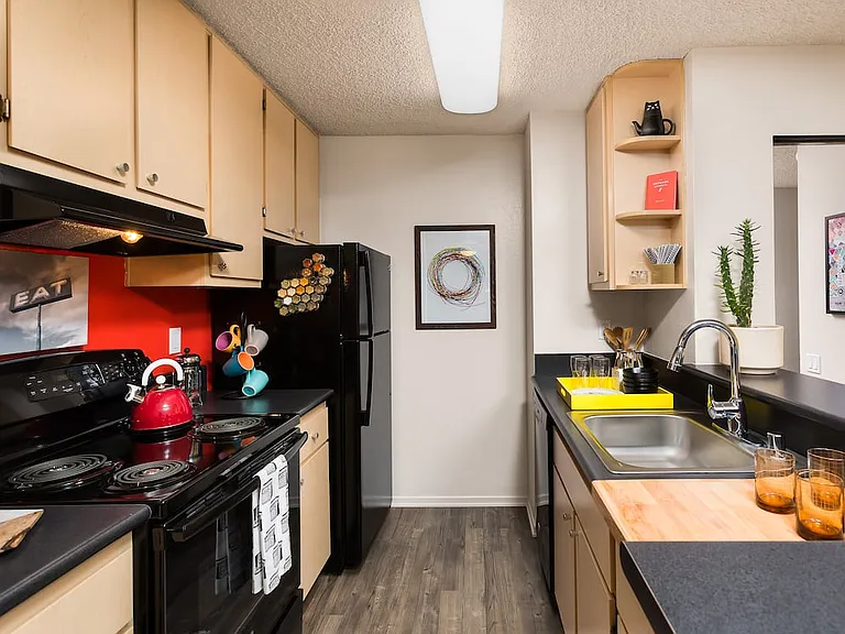 Classic Package II kitchen with black appliances, black laminate countertops, oak cabinetry, and hard surface flooring